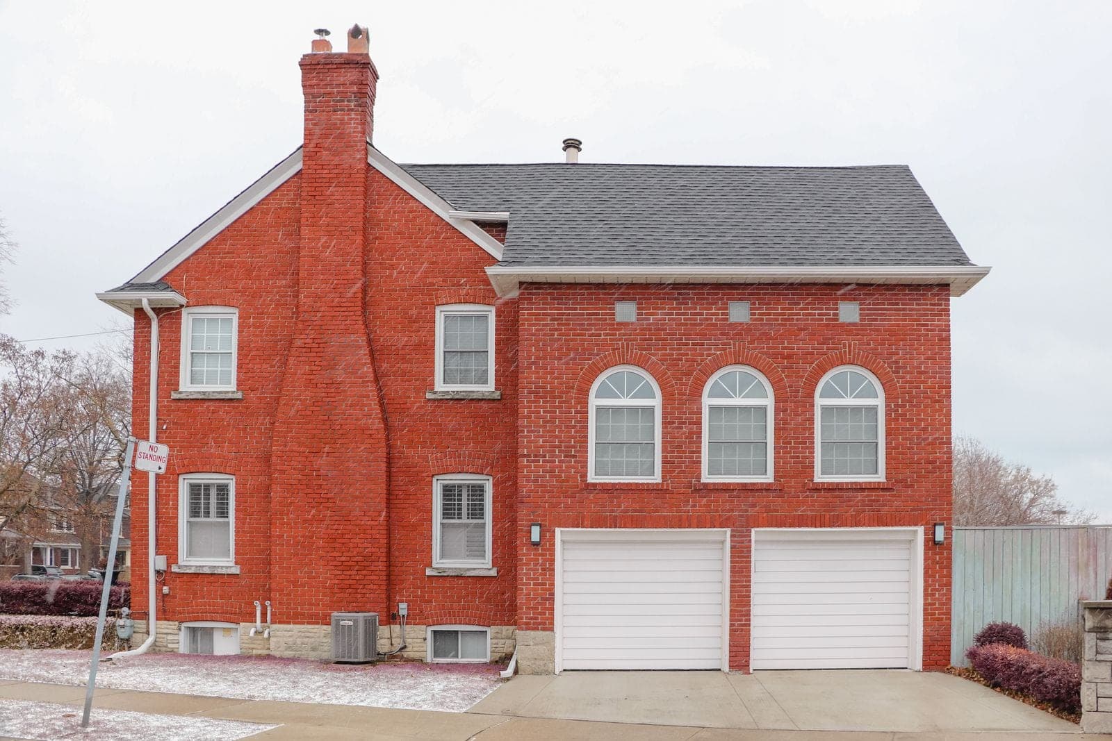 A red brick house with a tall brick chimney up the side wall